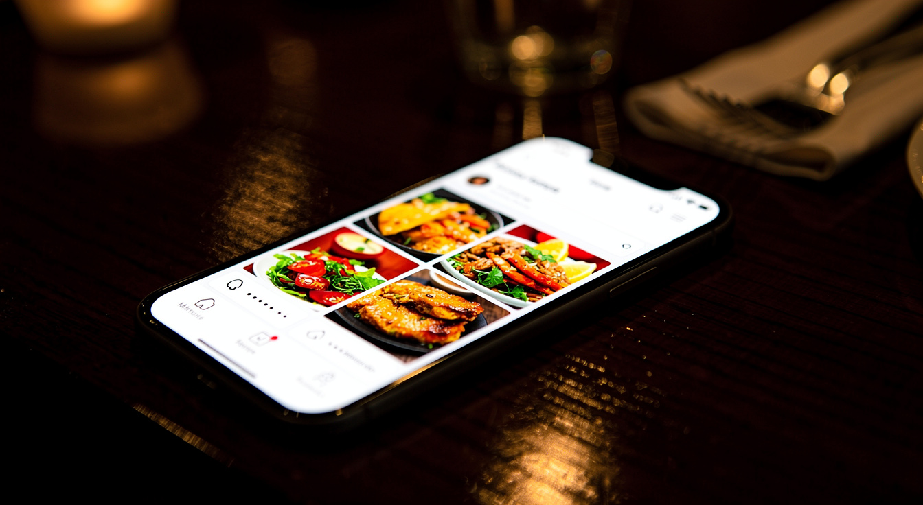 A restaurant online-ordering and loyalty app on a phone, feeding guest data into the CRM